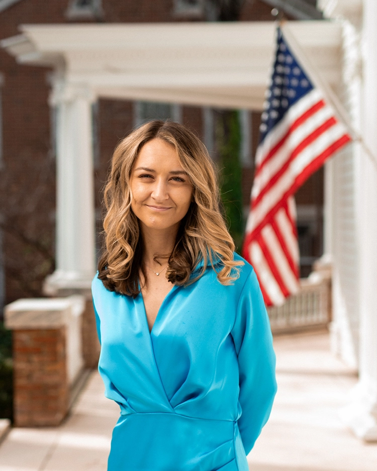 Anderson Clayton in a blue dress on the porch of the NC Democratic Party headquarters.